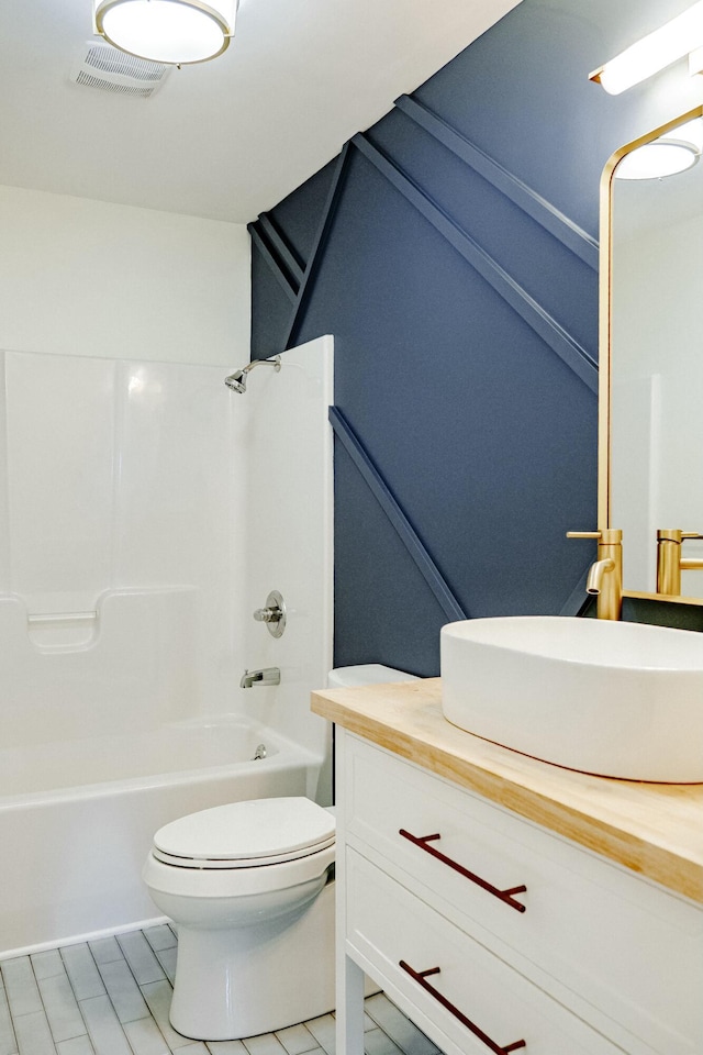 bathroom with visible vents, toilet, shower / bath combination, and vanity