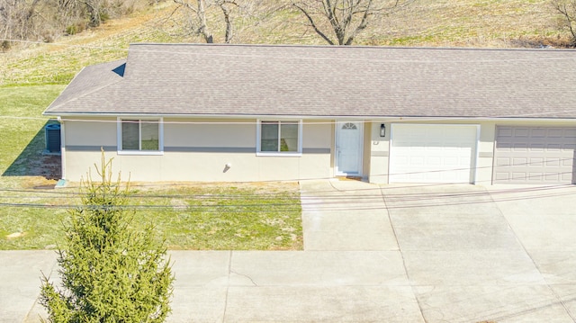 ranch-style house featuring stucco siding, a garage, driveway, and a shingled roof