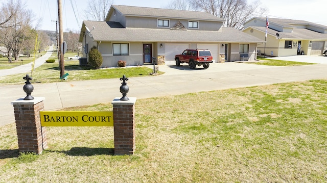 exterior space with a front yard, concrete driveway, an attached garage, and a shingled roof