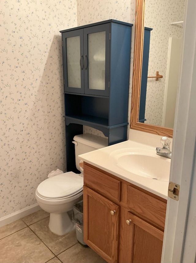 half bath featuring wallpapered walls, baseboards, toilet, tile patterned floors, and vanity