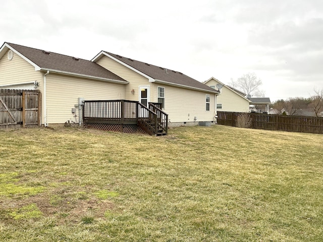 back of property with crawl space, a fenced backyard, a deck, and a yard