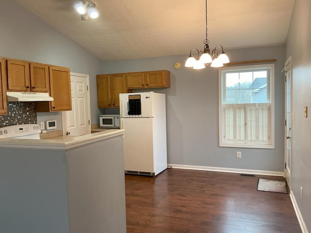 kitchen with white appliances, a notable chandelier, under cabinet range hood, and dark wood-type flooring