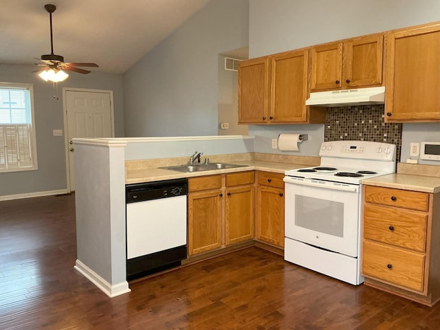 kitchen featuring white appliances, vaulted ceiling, light countertops, under cabinet range hood, and a sink