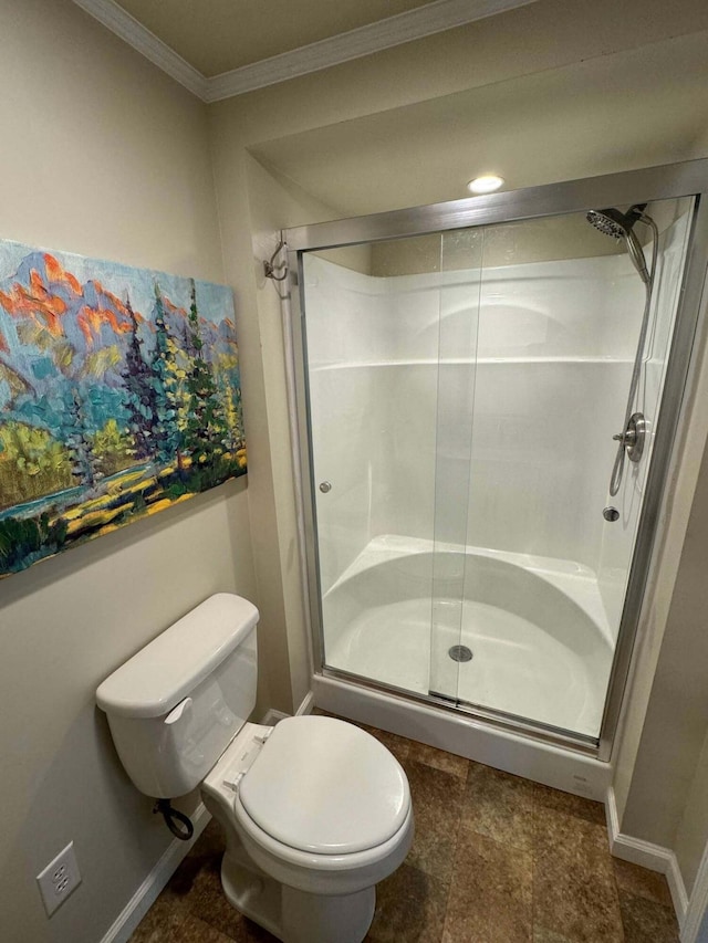 full bathroom featuring crown molding, a shower stall, toilet, and baseboards