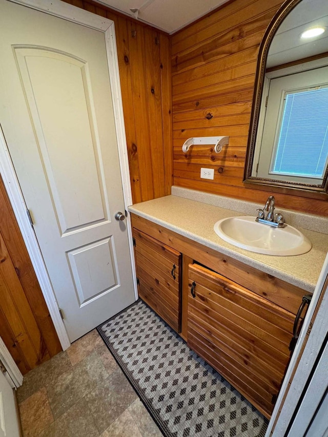 bathroom featuring wooden walls and vanity