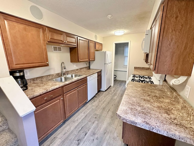 185 Woods Rd, Nancy, KY 42544 - kitchen with light wood finished floors, a sink, visible vents, white appliances, and a textured ceiling