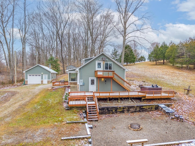 view of front of house featuring a fire pit, a garage, an outdoor structure, stairs, and a wooden deck