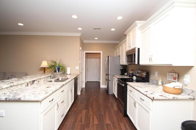 kitchen featuring visible vents, white cabinets, a peninsula, stainless steel appliances, and a sink