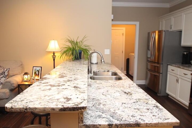 kitchen with dark wood-type flooring, a breakfast bar, a sink, ornamental molding, and stainless steel refrigerator with ice dispenser