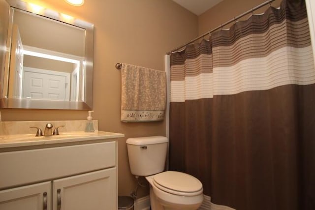 full bath with curtained shower, vanity, and toilet