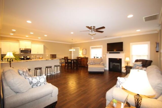 living room featuring crown molding, visible vents, dark wood-type flooring, and recessed lighting