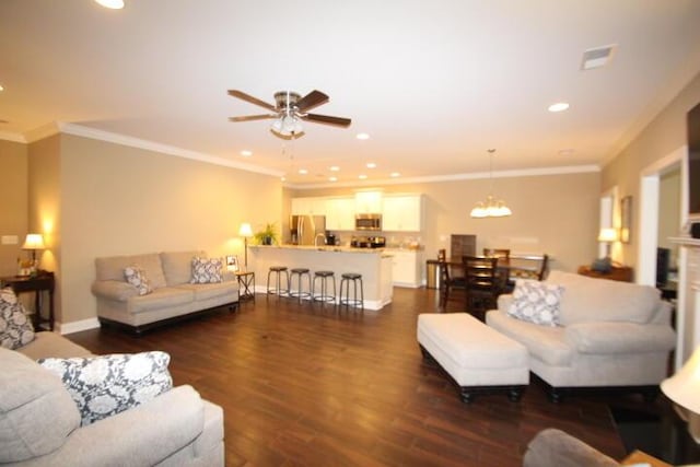 living area featuring ornamental molding, recessed lighting, dark wood-style flooring, and visible vents