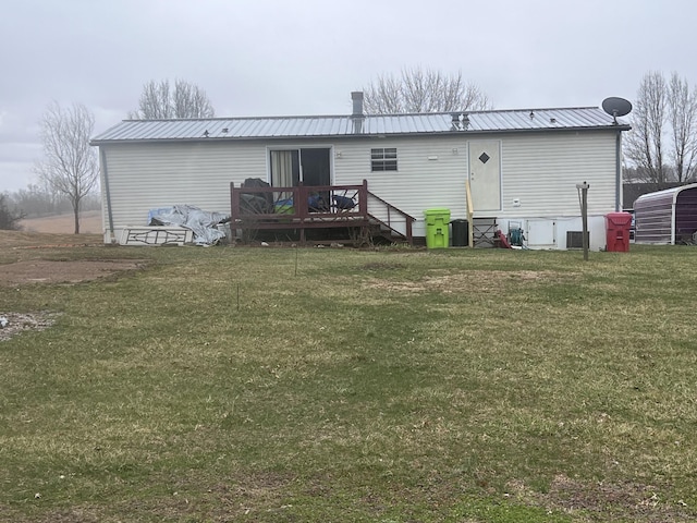 rear view of house with metal roof, a lawn, cooling unit, and a wooden deck