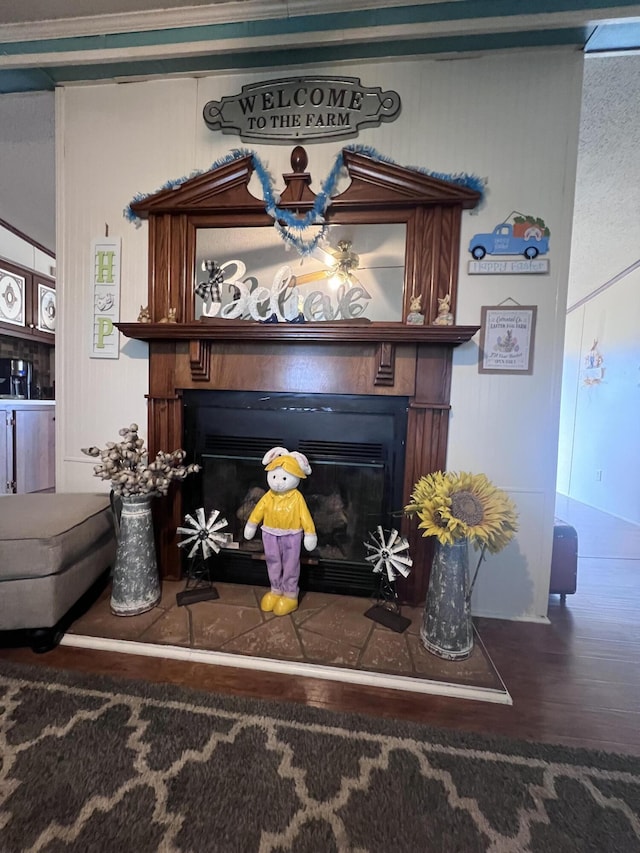 interior details featuring a glass covered fireplace and wood finished floors