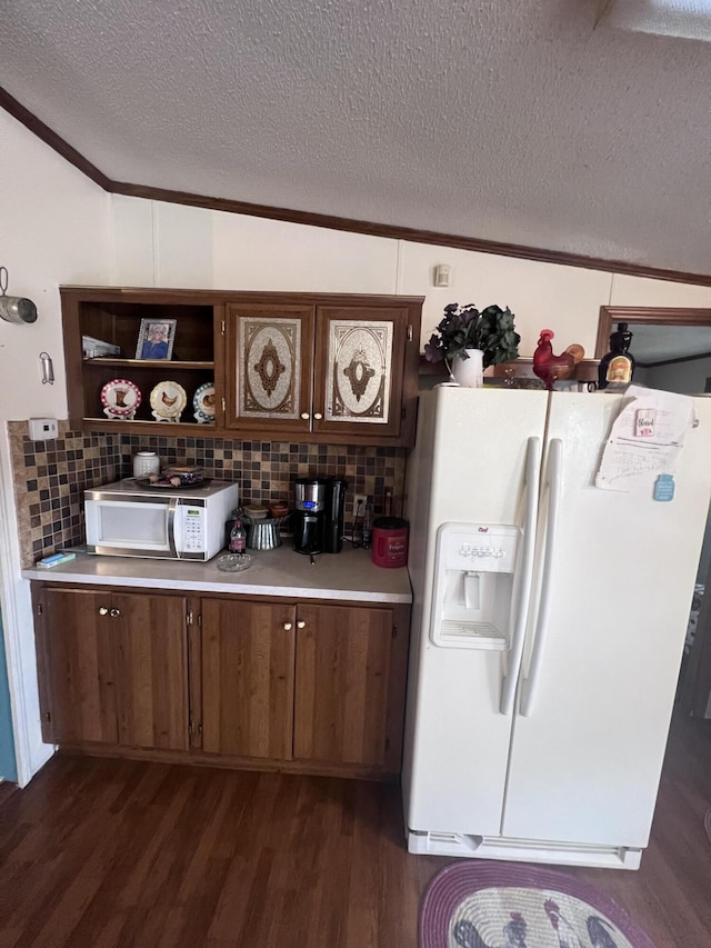 kitchen with white appliances, light countertops, ornamental molding, decorative backsplash, and dark wood finished floors