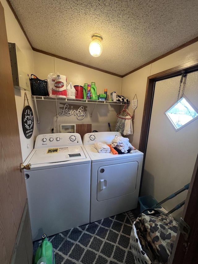 clothes washing area featuring a textured ceiling, laundry area, ornamental molding, and washer and dryer