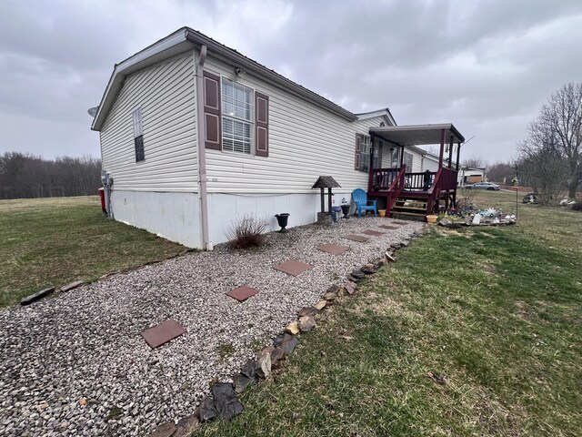 view of home's exterior featuring a deck and a yard