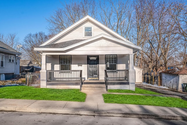 bungalow-style home with covered porch and fence