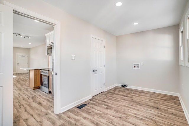 washroom featuring laundry area, baseboards, visible vents, light wood-type flooring, and washer hookup