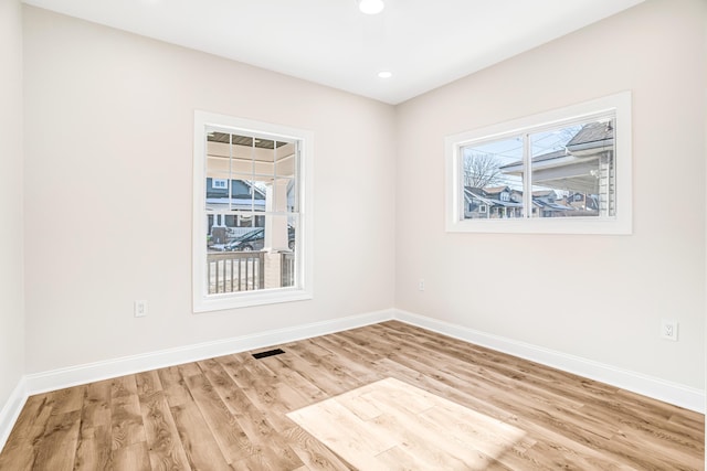 empty room featuring baseboards, visible vents, wood finished floors, and recessed lighting