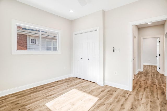 unfurnished bedroom with light wood-style floors, baseboards, a closet, and recessed lighting