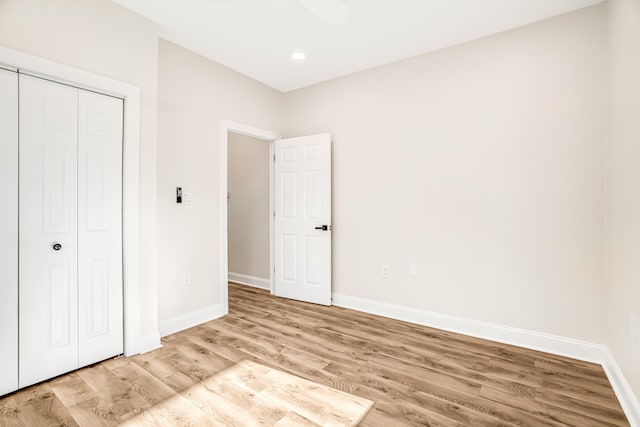 unfurnished bedroom with light wood-style floors, recessed lighting, a closet, and baseboards