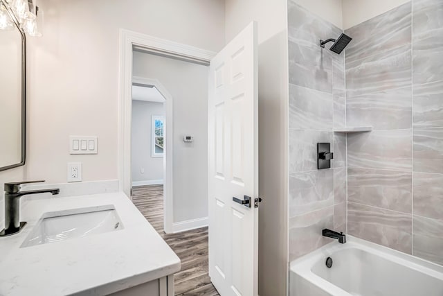 bathroom with baseboards, vanity, shower / tub combination, and wood finished floors