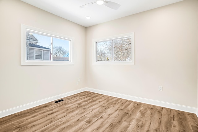 empty room featuring ceiling fan, light wood-style flooring, and baseboards