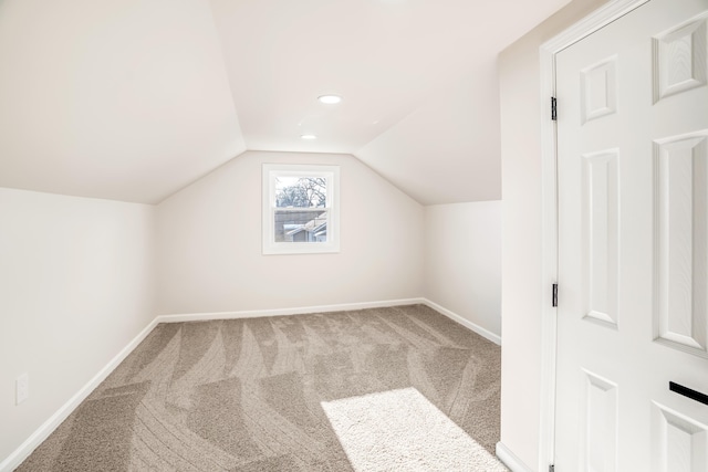 additional living space with baseboards, vaulted ceiling, and carpet flooring