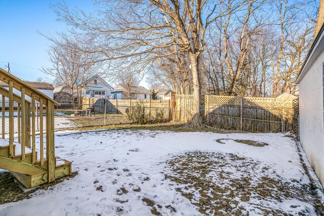 snowy yard featuring fence