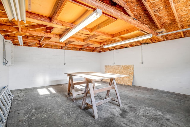 basement featuring a garage and concrete block wall