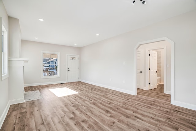 unfurnished living room featuring recessed lighting, baseboards, and light wood finished floors