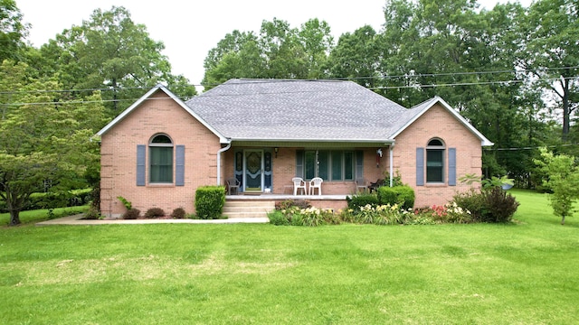 ranch-style house with brick siding, a shingled roof, a front lawn, and covered porch