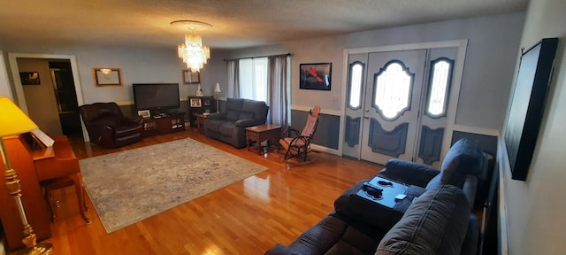 living area featuring a chandelier and wood finished floors