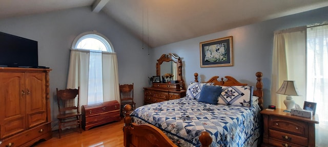 bedroom featuring vaulted ceiling with beams and light wood-style flooring