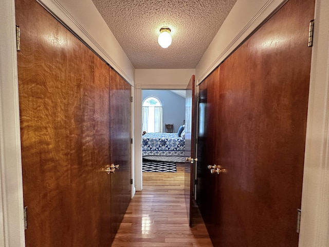 hall featuring a textured ceiling and wood finished floors