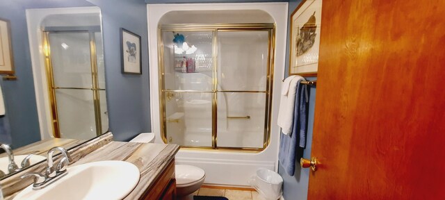 bathroom with combined bath / shower with glass door, vanity, and toilet