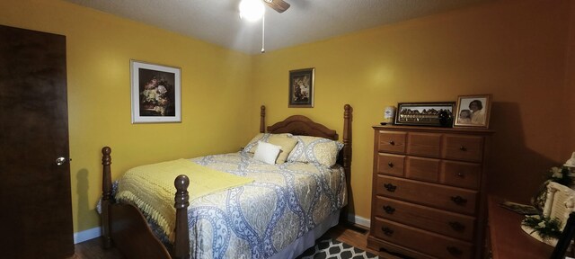 bedroom featuring baseboards, dark wood finished floors, and a ceiling fan