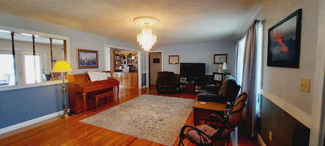 interior space featuring a chandelier, baseboards, and wood finished floors