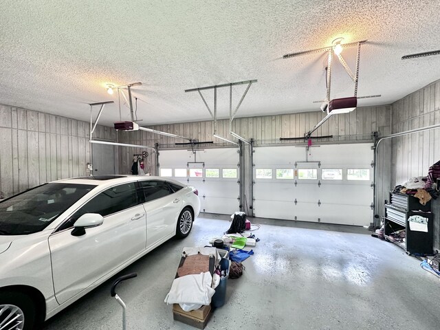 garage featuring wooden walls and a garage door opener