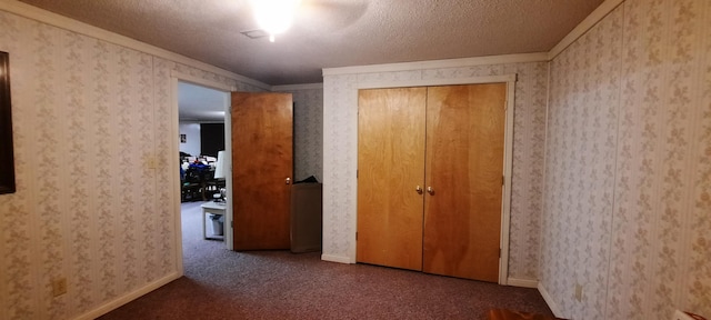 hall with wallpapered walls, baseboards, ornamental molding, carpet, and a textured ceiling