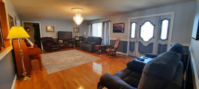 living area with wood finished floors and an inviting chandelier