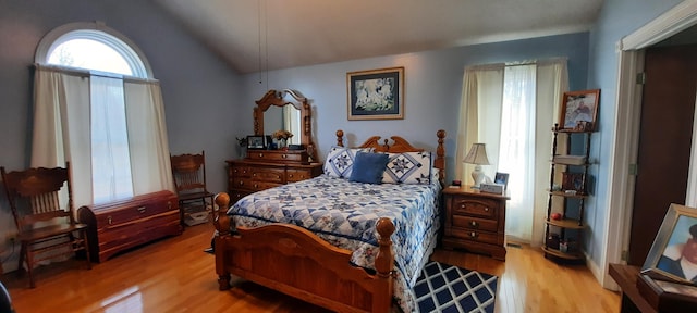 bedroom featuring lofted ceiling and light wood-style flooring