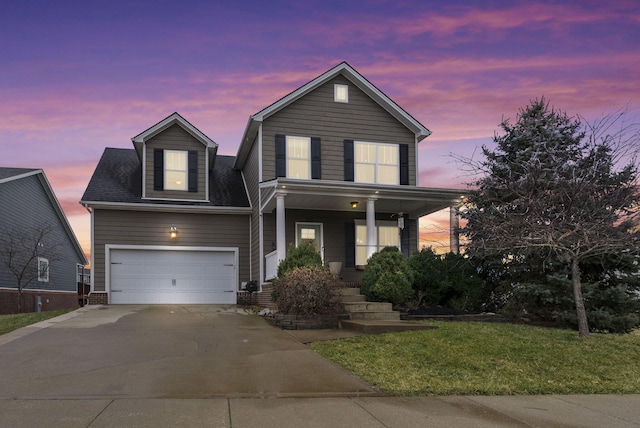 traditional home with a garage, a front yard, covered porch, and driveway