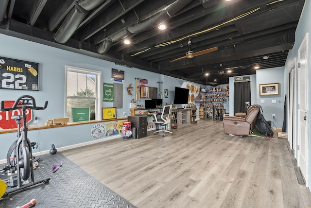 interior space with wood finished floors, a ceiling fan, and baseboards