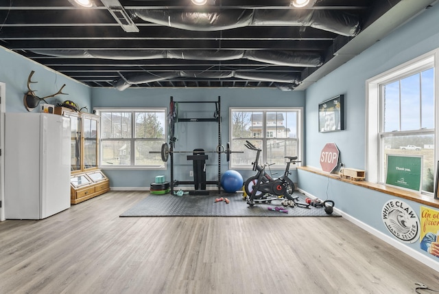 exercise room with wood finished floors and baseboards