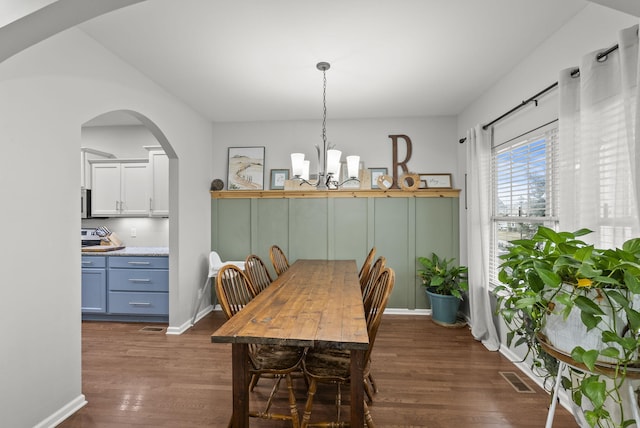 dining room featuring dark wood-style floors, baseboards, visible vents, and an inviting chandelier