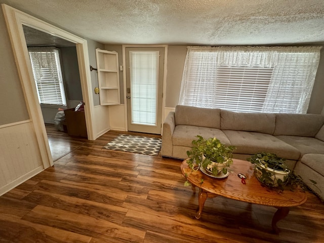 living room with a textured ceiling and wood finished floors