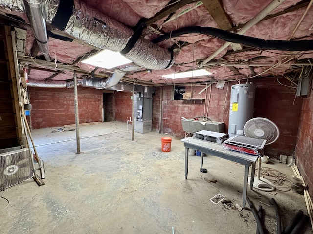 unfinished basement with concrete block wall, electric water heater, and heating unit