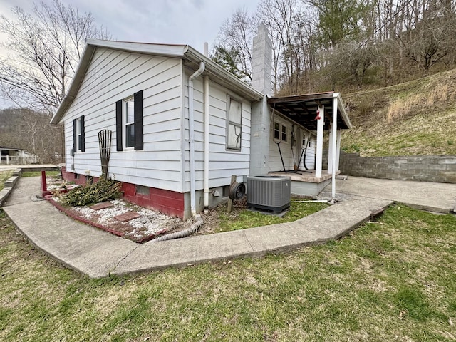 view of property exterior with a chimney and cooling unit